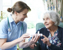 nurse giving medicine to an elderly woman